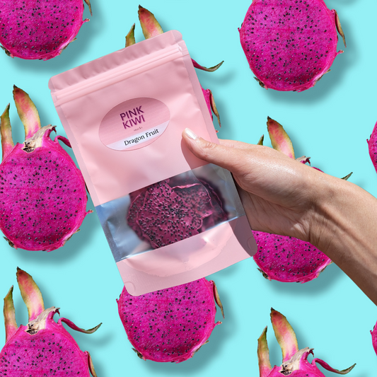 Hand holding Pink Kiwi dried dragon fruit snack pouch with vivid pink dragon fruit background on blue, showcasing exotic healthy fruit snack.